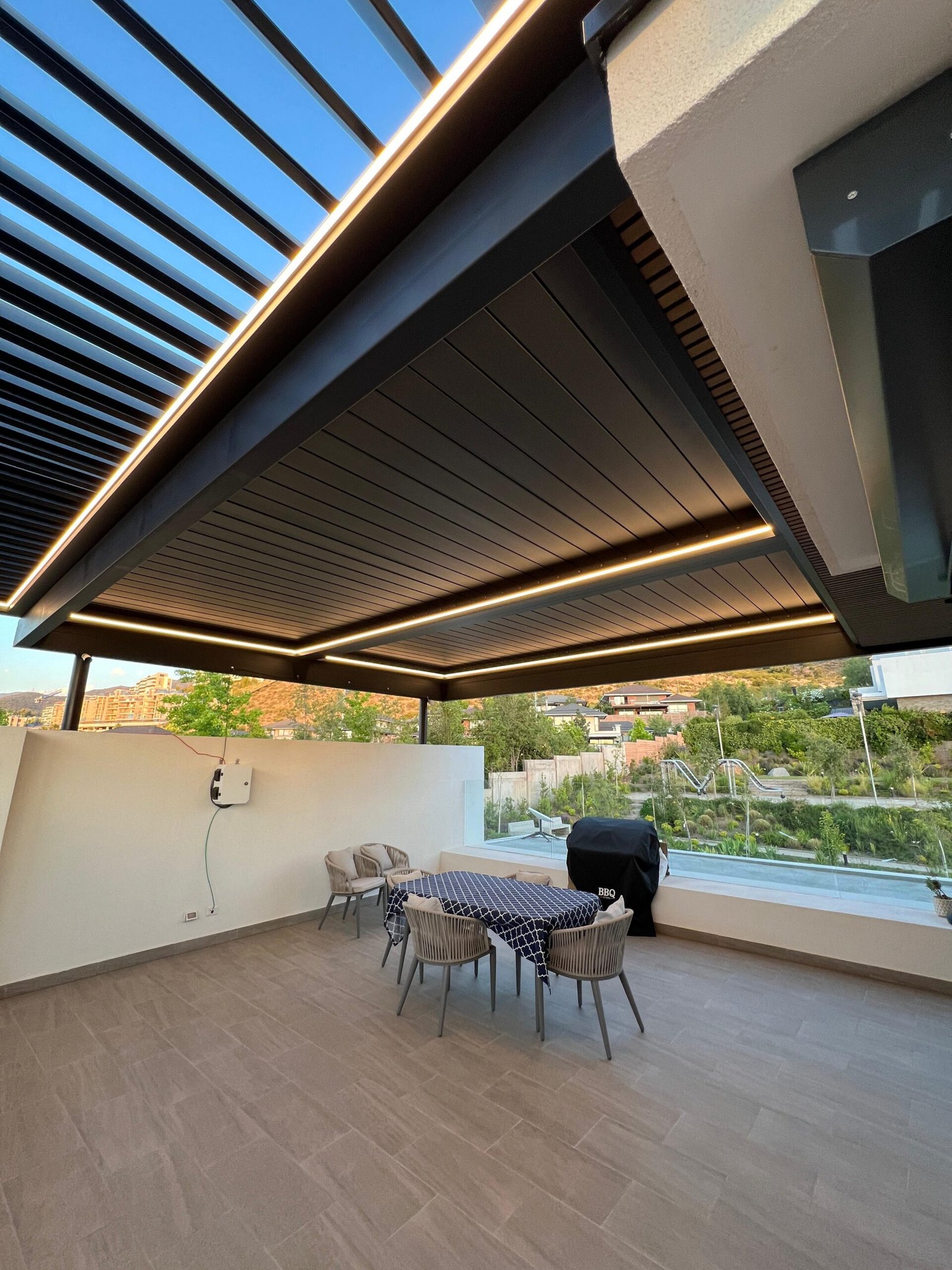 Pérgola de aluminio con aspas abiertas e iluminación LED sobre una terraza